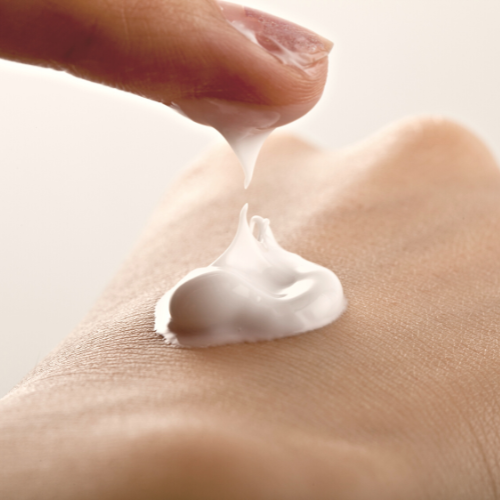 Skin lotion on hand, being applied by a left index finger