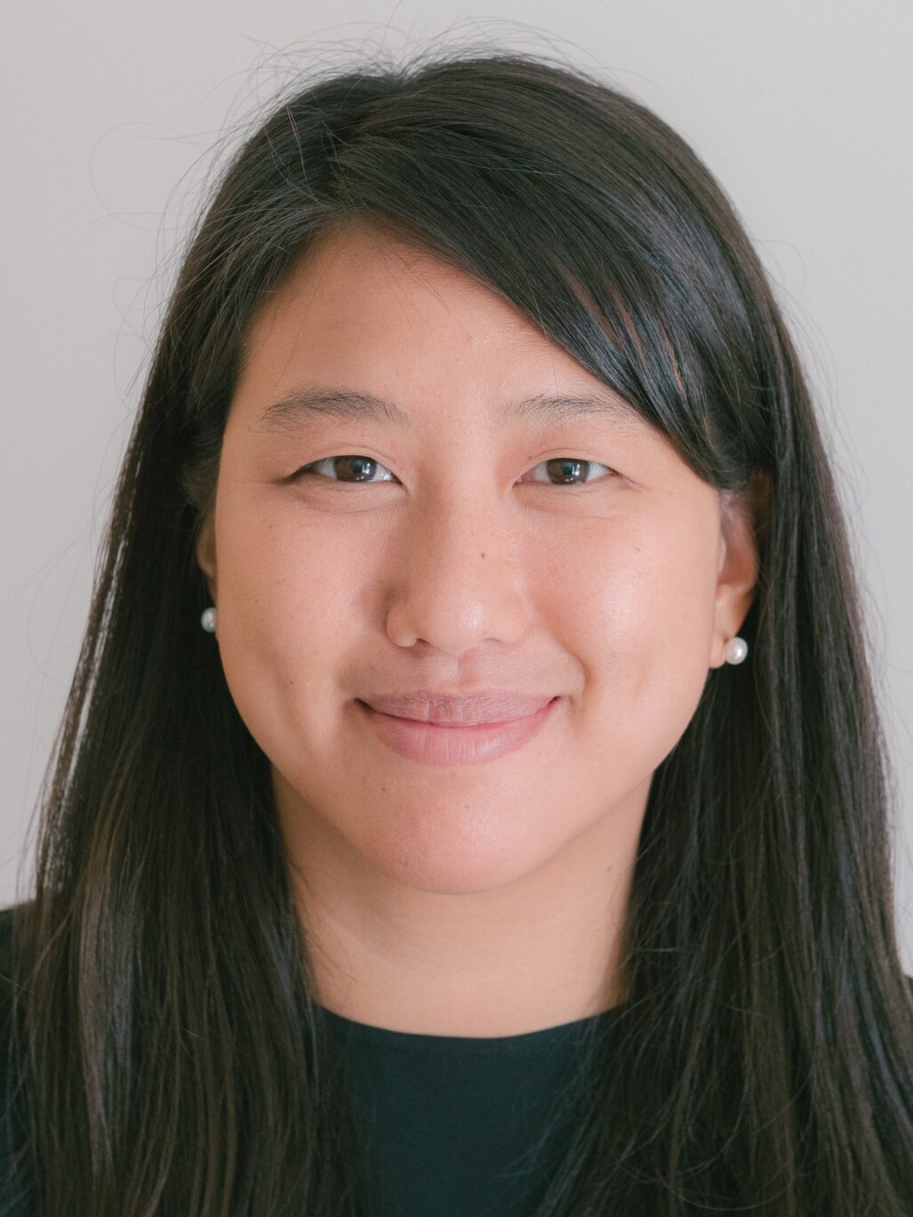 Photo of Dr. Julie HWang smiling, with black hair and a black shirt