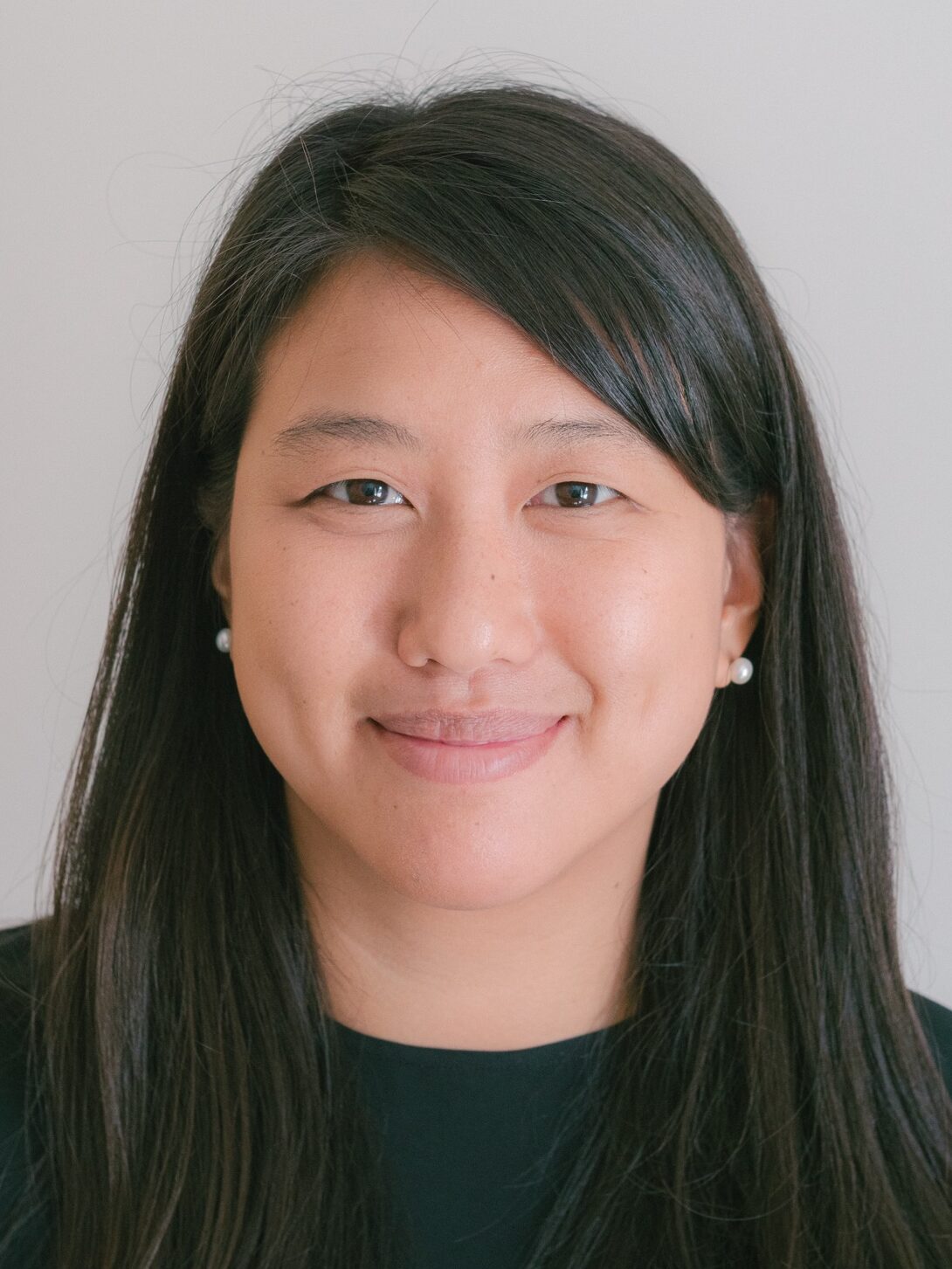 Photo of Dr. Julie HWang smiling, with black hair and a black shirt